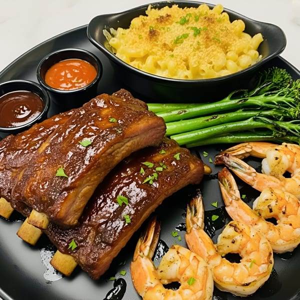 Snooks Grill & Cocktails' ribs and shrimp platter with mac and cheese, broccolini, and dipping sauces.