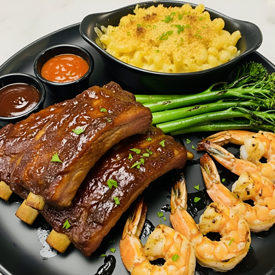 Snooks Grill & Cocktails' ribs and shrimp platter with mac and cheese, broccolini, and dipping sauces.
