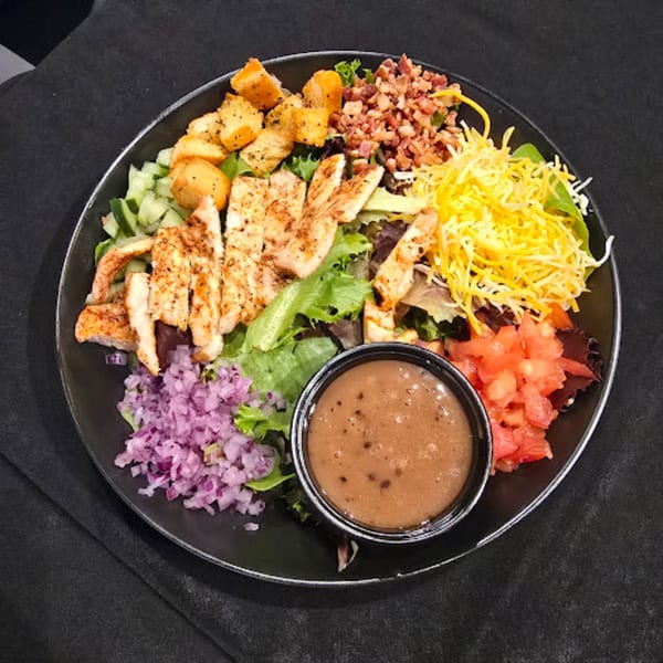 Snooks Grill & Cocktails' grilled chicken salad with bacon, cheese, croutons, and dressing.