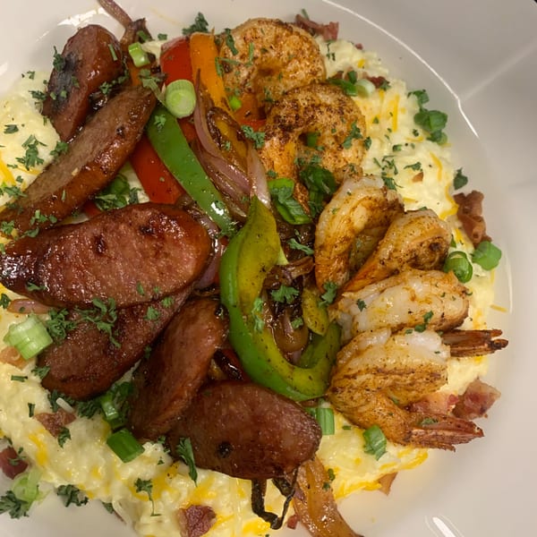 Snooks Grill's shrimp and grits with sausage, bell peppers, onions, and bacon bits.