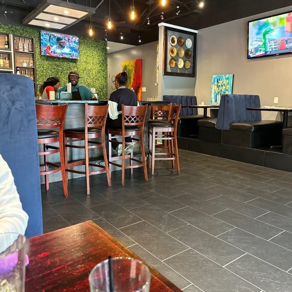 Interior of Snooks Grill & Cocktails with patrons at the bar, booth seating, and TVs on the walls.